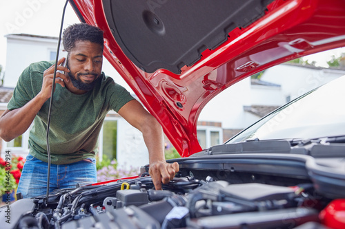 Photos Man Looking At Engine After Car Breakdown Calling Auto Recovery On Mobile Phone