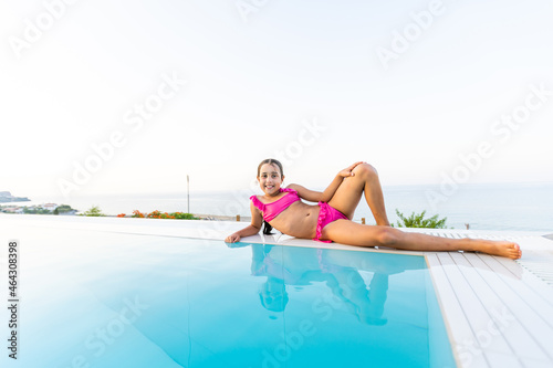 Closeup portrait of cute little arabic girl swimming in the pool, happy child having fun in water, beach resort, summer vacation and holidays concept