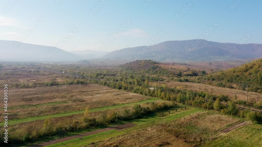 Trucks move along the highway, which stretches among the fields. Aerial natural landscape. Trucks move along the highway, which stretches among the fields. Aerial natural landscape.