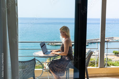 woman in hotel room with notebook and ocean view
