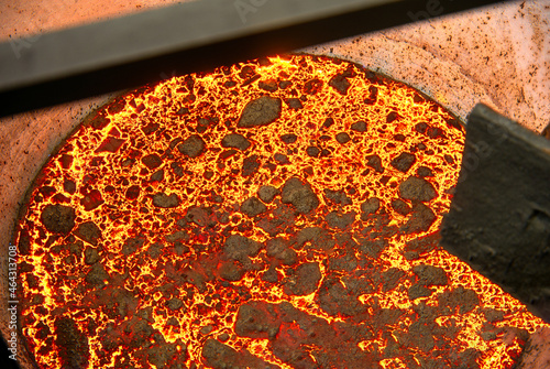 The surface of a hot liquid slag in a metallurgical ladle. Thick crust covered with trash net