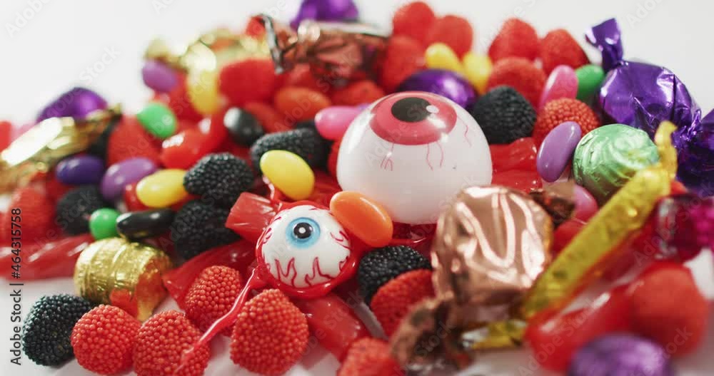 Close up view of variety of halloween candies fallen against grey background Close up view of variety of halloween candies fallen against grey background