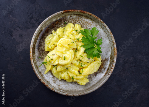 Canvastavla Traditional German potato salad with onion and chives served as top view in a de