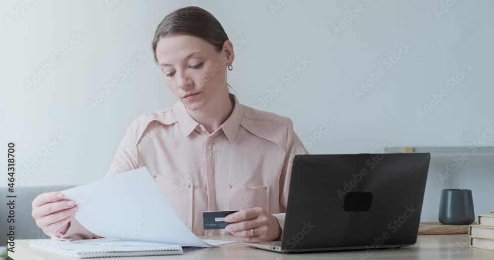Focused young businesswoman holding financial document with trading statistics and investments profit results. Paying bills and domestic payments via electronic bank. Analyzing sales trading report Focused young businesswoman holding financial document with trading statistics and investments profit results. Paying bills and domestic payments via electronic bank. Analyzing sales trading report