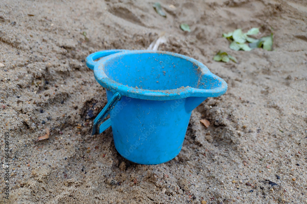 Toy blue bucket, forgotten in the sandbox Toy blue bucket, forgotten in the sandbox