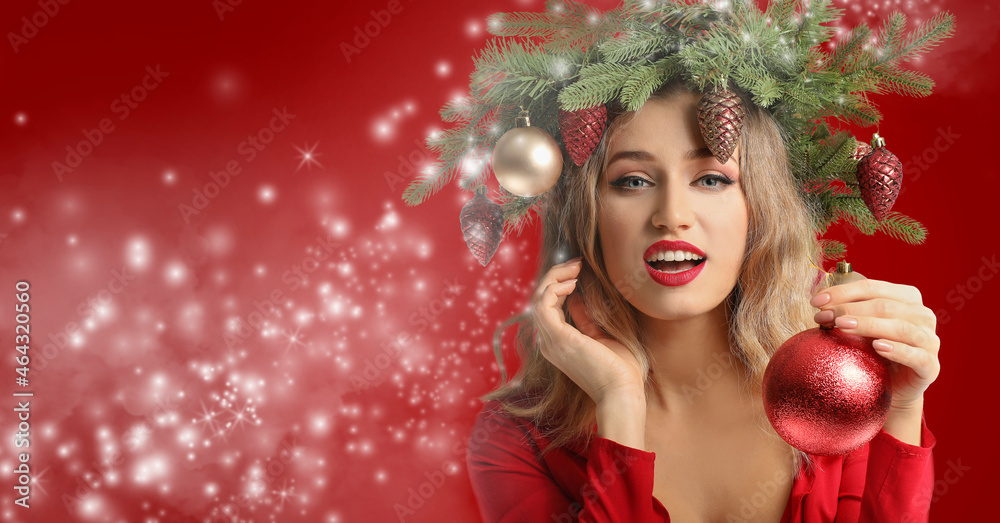 Beautiful young woman with Christmas wreath on color background