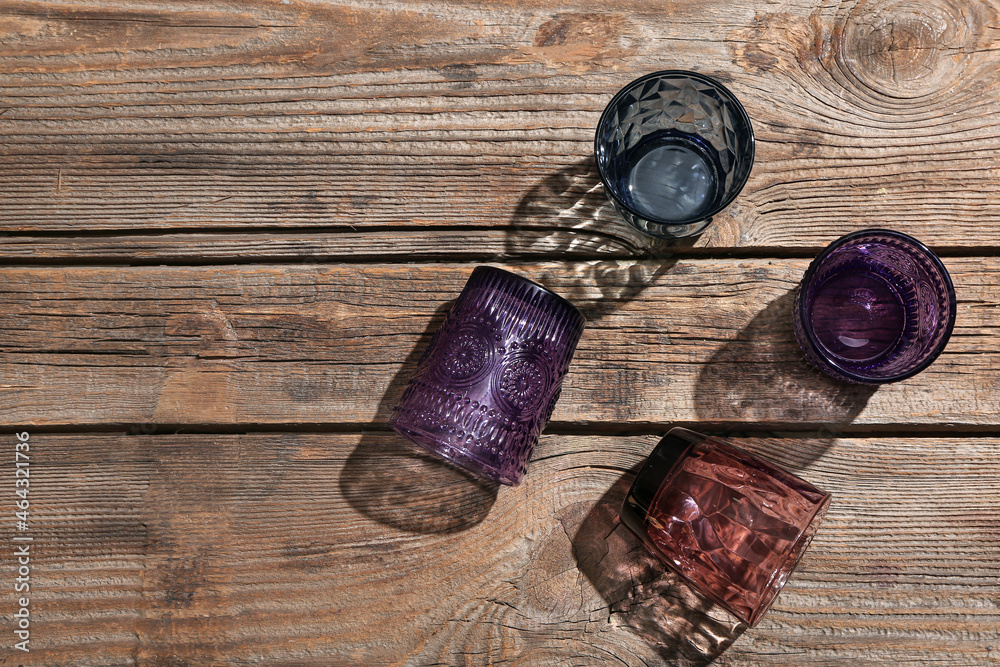 Beautiful empty colorful glasses on wooden background Beautiful empty colorful glasses on wooden background
