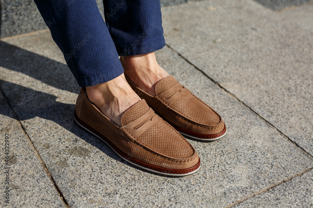 Male brown shoes made of genuine leather close-up on male feet Male brown shoes made of genuine leather close-up on male feet