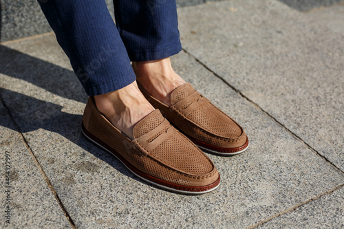 Male brown shoes made of genuine leather close-up on male feet