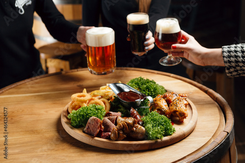 A scene in a pub: beer snack plate and people having beers in the background