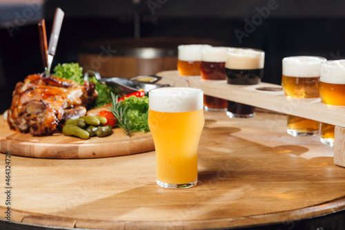 A light unfiltered craft beer at the table, with other beers and snaks at the background