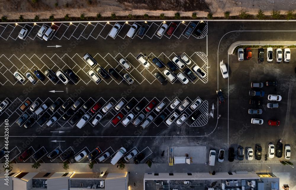 Drone aerial view of parking lots with cars at night. Crowded shopping mall car park. Drone aerial view of parking lots with cars at night. Crowded shopping mall car park.