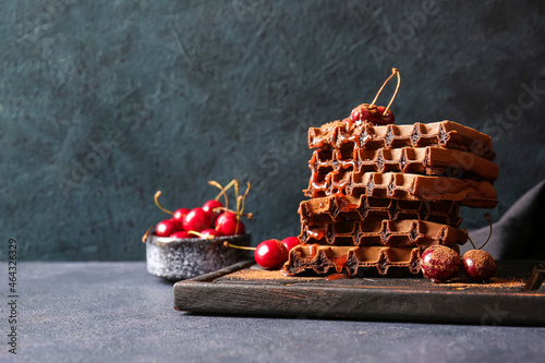 Fototapeta Naklejka Na Ścianę i Meble -  Wooden board of delicious Chocolate Belgian Waffles with cherry on black background