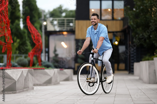 Man riding bicycle on city street © Pixel-Shot