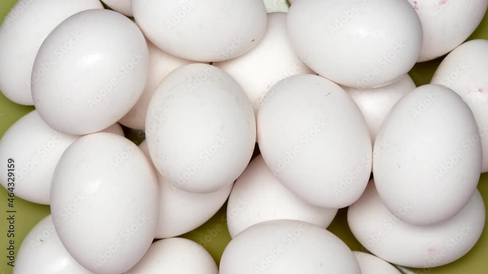 Rotating White Chicken Eggs In A Green Plate. Top View. Close Up. Rotating White Chicken Eggs In A Green Plate. Top View. Close Up.