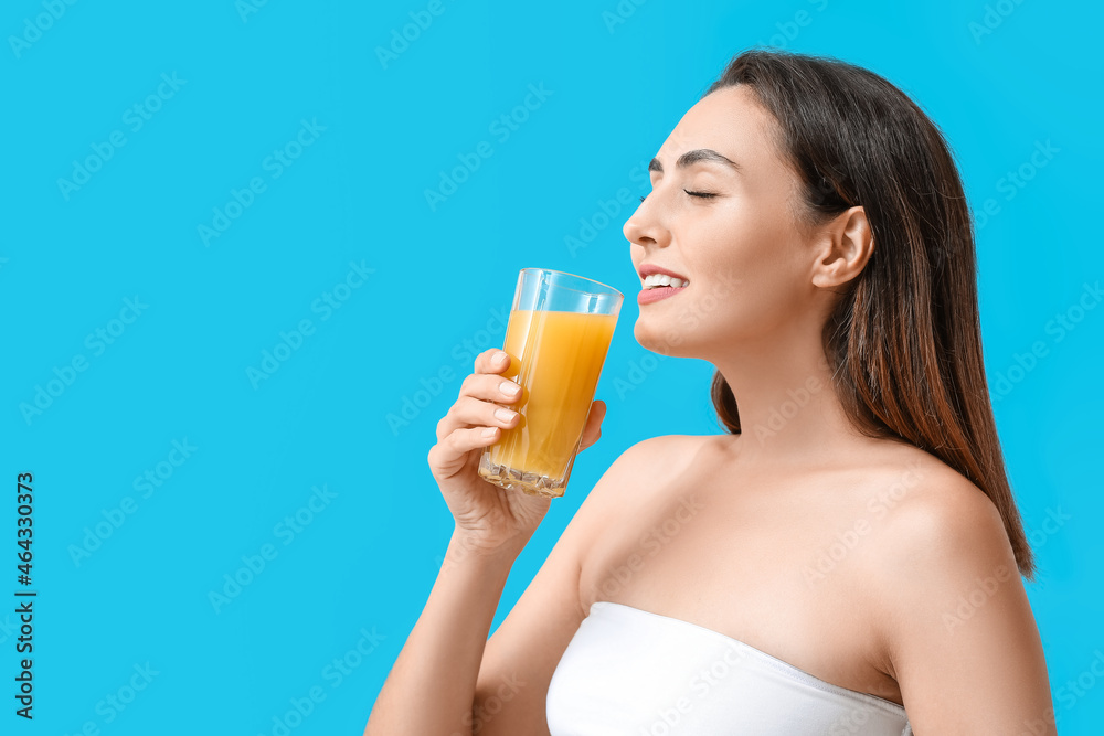 Young woman with glass of orange juice on color background Young woman with glass of orange juice on color background