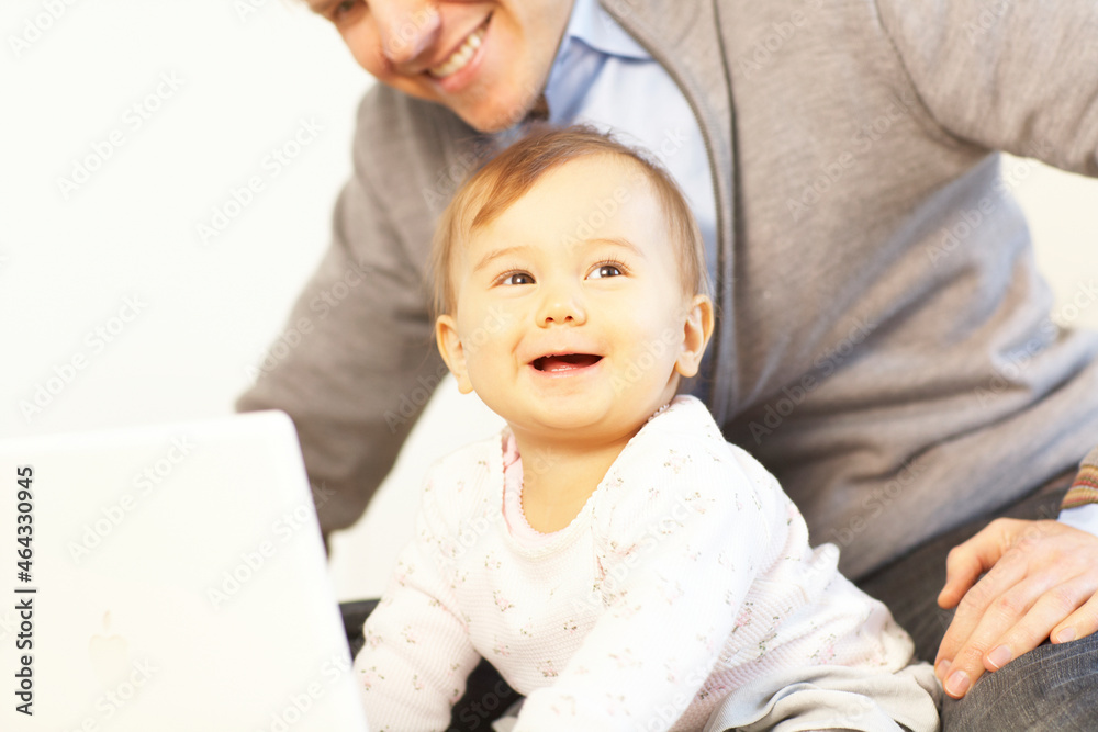 床の上でノートパソコンの画面を見る赤ちゃんと父親 床の上でノートパソコンの画面を見る赤ちゃんと父親