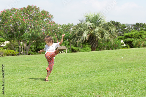 芝生の上でキックするハーフの男の子 photo