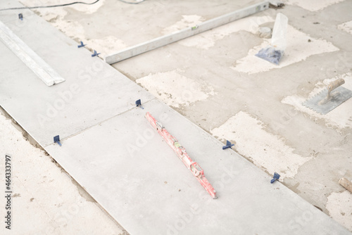 Large Ceramic tiles in the loft style, concrete. Repair of the dining room in the house, place for kitchen, floor covering change. Empty interior for design, gray concrete wall.