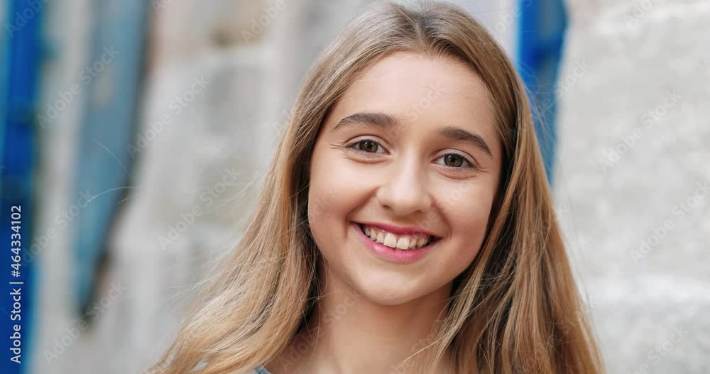Close up portrait of beautiful caucasian teenage girl standing in the middle of street alone looking at camera and cute smiling. Close up portrait of beautiful caucasian teenage girl standing in the middle of street alone looking at camera and cute smiling.