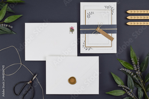 Modern wedding invitation blank flat lay mock-ups. Wedding stationery includes invitation, rsvp, save the date, envelopes, wax seal and stamp. Customize an empty clean design on black background. 