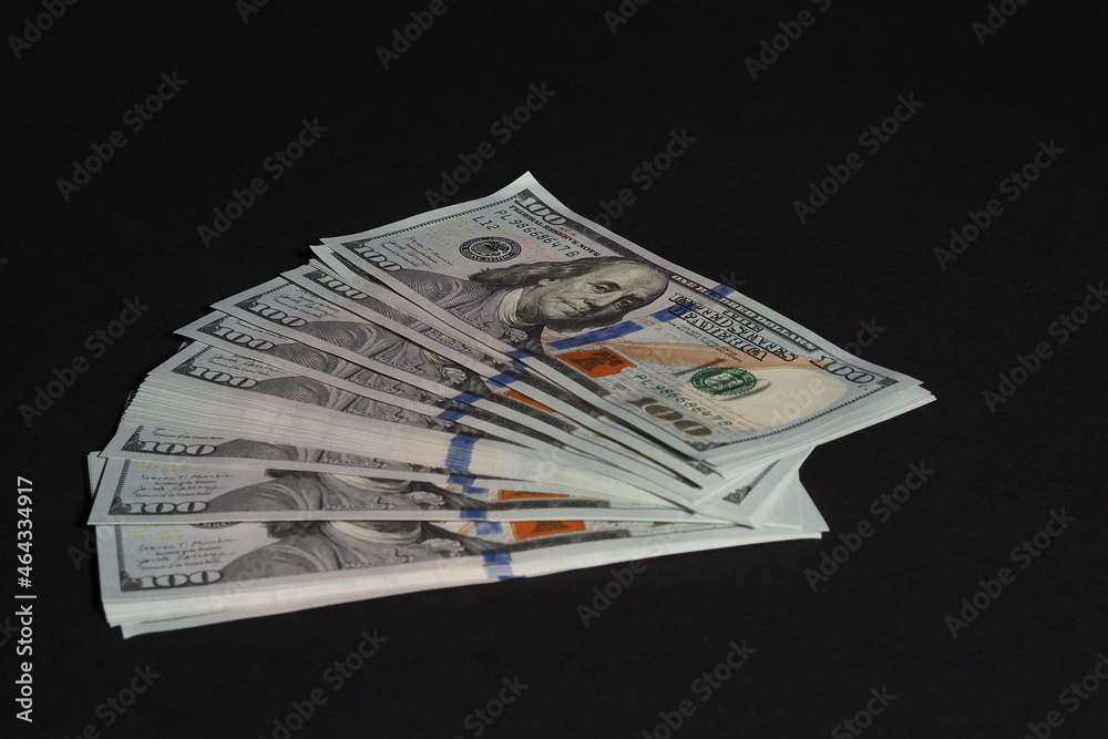 The American dollar. Paper bills of a hundred dollars on a black background. The American dollar. Paper bills of a hundred dollars on a black background.