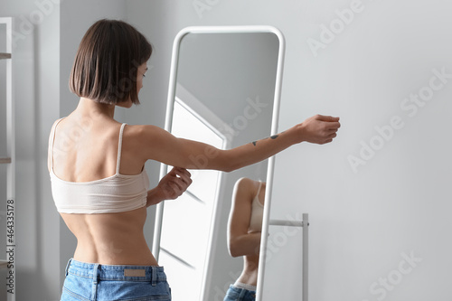 Canvastavla Young skinny woman in front of mirror at home. Anorexia concept