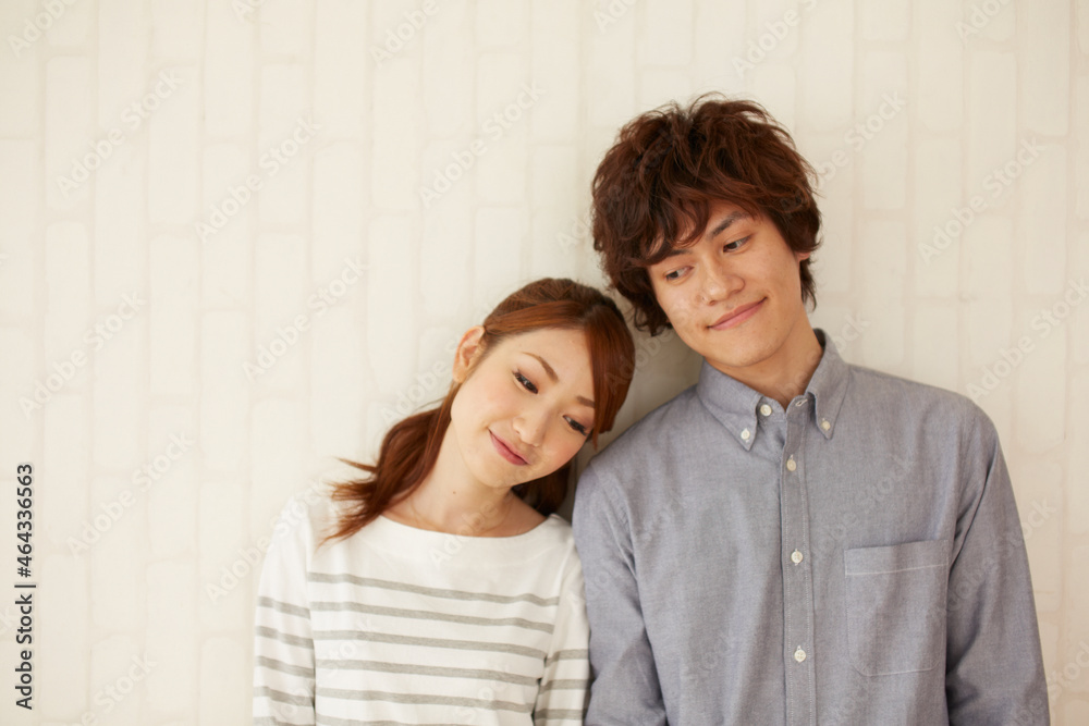 壁の前で寄り添う男女 壁の前で寄り添う男女
