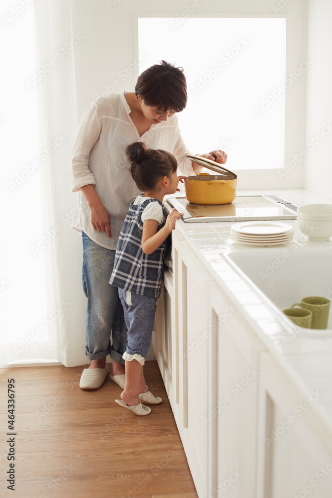 キチンでママの料理を手伝う女の子 キチンでママの料理を手伝う女の子