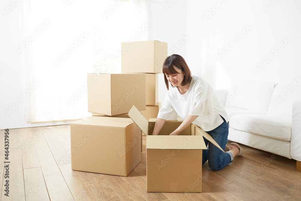 引っ越しの段ボールから荷物を出す女性 引っ越しの段ボールから荷物を出す女性
