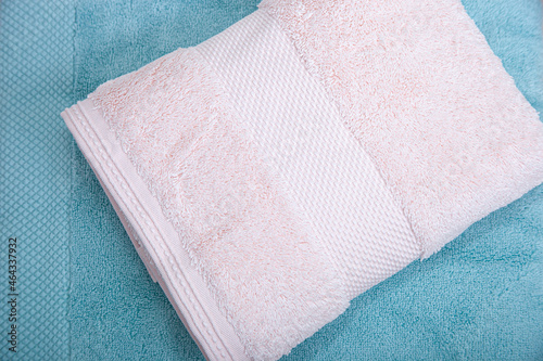 Stack of white towels and light blue towel isolated on white background.