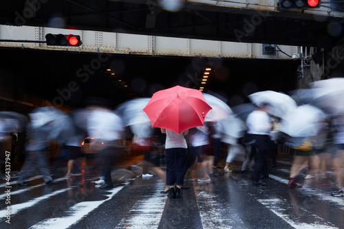 歩道で傘を持ってたたずむ女性 photo