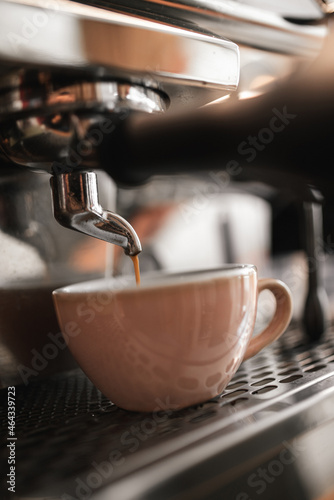 Espresso machine pours fresh black coffee closeup