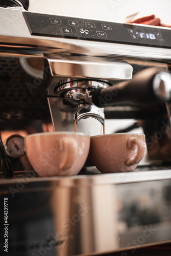 Espresso machine pours fresh black coffee closeup