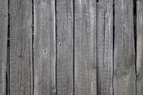 An old fence made of dried and cracked wooden panels as a background