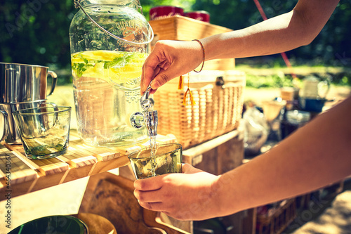 ウォータージャグのお水をグラスに注ぐ女性