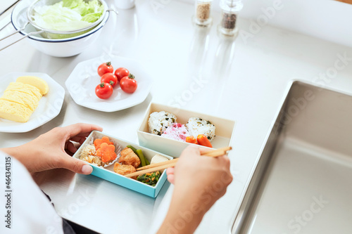 キッチンでお弁当を作る女性の手元 photo