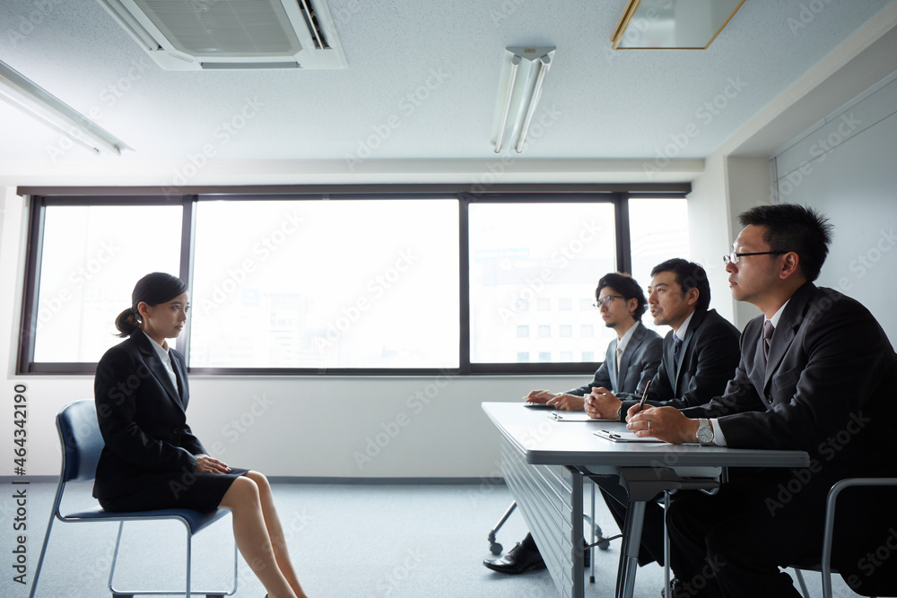 オフィスで面接を受けている女性と面接官 オフィスで面接を受けている女性と面接官