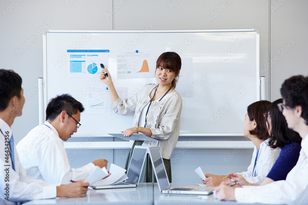 プレゼンをしている女性と話し合う社員