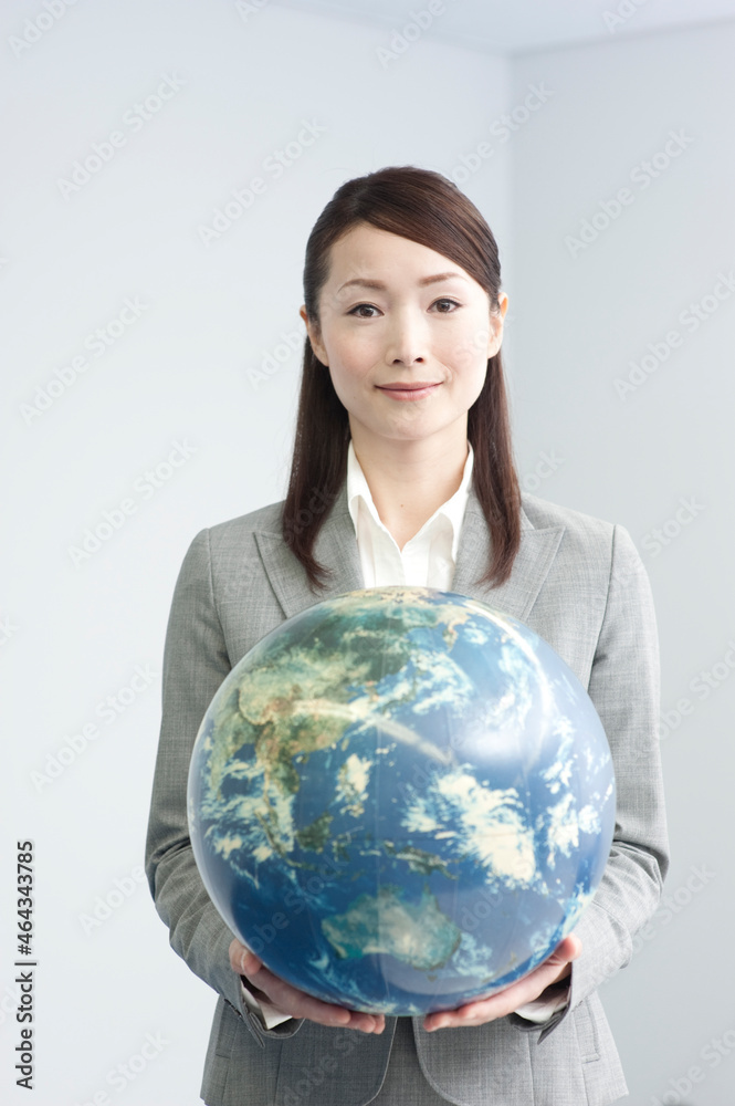 地球儀を両手で持つビジネスウーマン