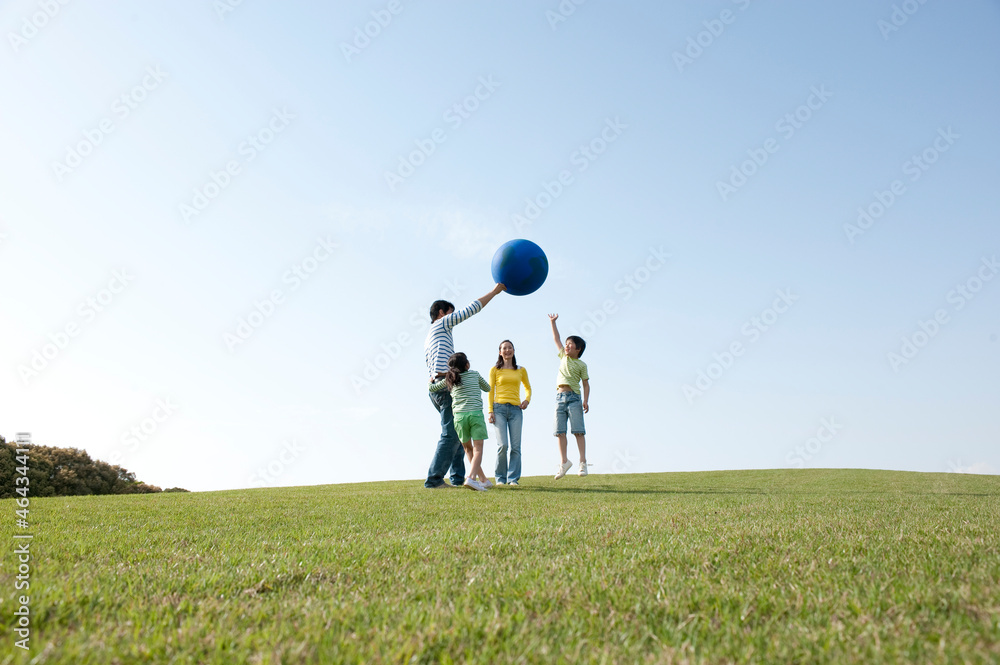 公園の青い風船で遊ぶ4人家族
