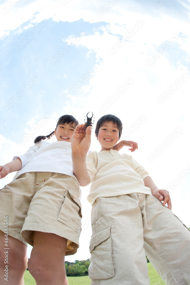 クワガタ虫を持つ男の子と女の子