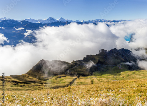 Autumn fog rising from the Brienzsee Lake over the cliff group Dirrengrind at the Rothorn with Alps peak chain at the background photo