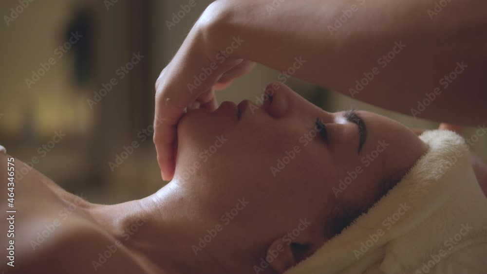 Young beautiful Caucasian woman lying on spa bed get facial massage treatment with aroma essential oil skincare from massage therapist at beauty salon. Wellness health care body massage spa concept. Young beautiful Caucasian woman lying on spa bed get facial massage treatment with aroma essential oil skincare from massage therapist at beauty salon. Wellness health care body massage spa concept.