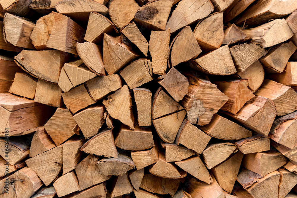 Background of dry chopped logs firewood used as a decor. The pile of beech logs outdoor ready for winter and heating Background of dry chopped logs firewood used as a decor. The pile of beech logs outdoor ready for winter and heating