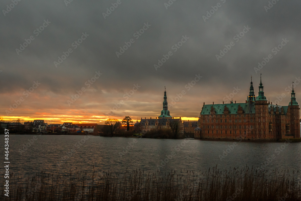 Frederiksborg castle on the sunset, with lake and tree in the foreground, Hillerod, Denmark