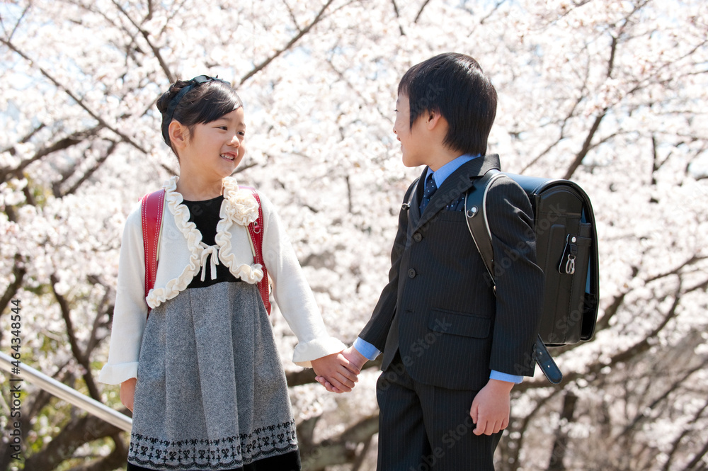 桜と新入学のランドセルの小学生男女 桜と新入学のランドセルの小学生男女