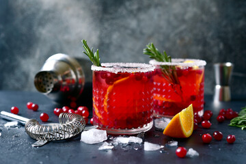Red christmas cocktail with cranberries and oranges.