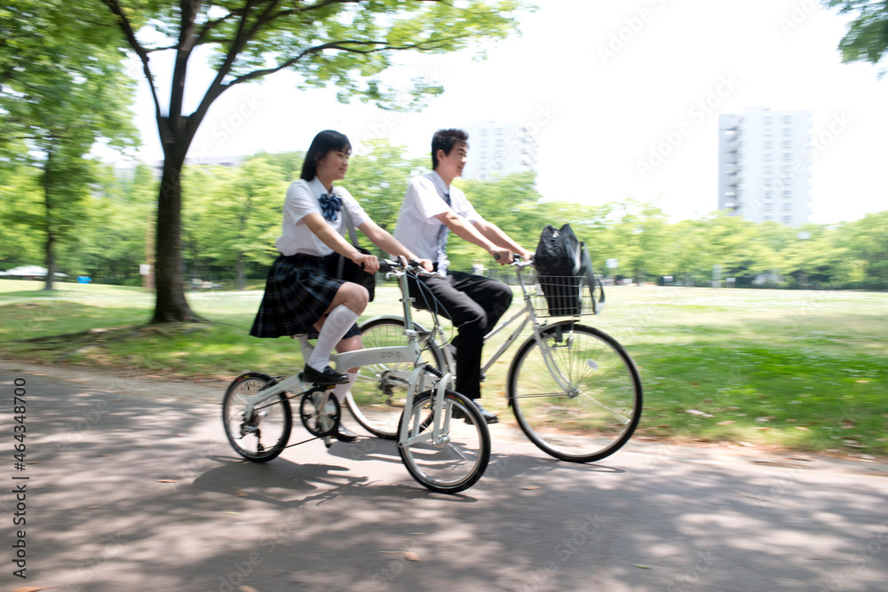 自転車に乗って走る高校生カップル 自転車に乗って走る高校生カップル