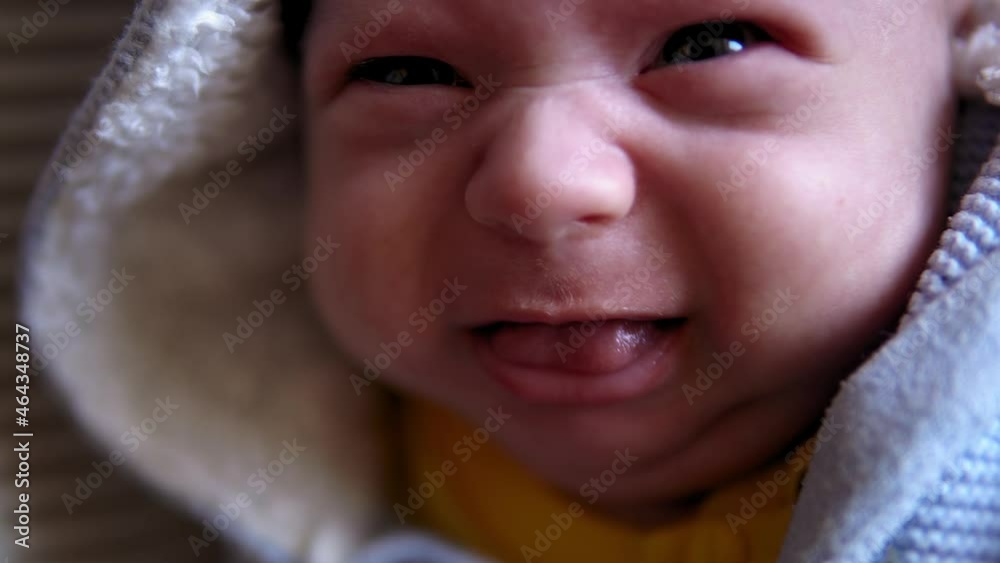 look of baby in camera close up shot. infant, childhood, parental love, emotion concept - cute smiling face of brown-eyed chubby newborn with dummy in soft blue jacket awake spits out pacifier cries look of baby in camera close up shot. infant, childhood, parental love, emotion concept - cute smiling face of brown-eyed chubby newborn with dummy in soft blue jacket awake spits out pacifier cries